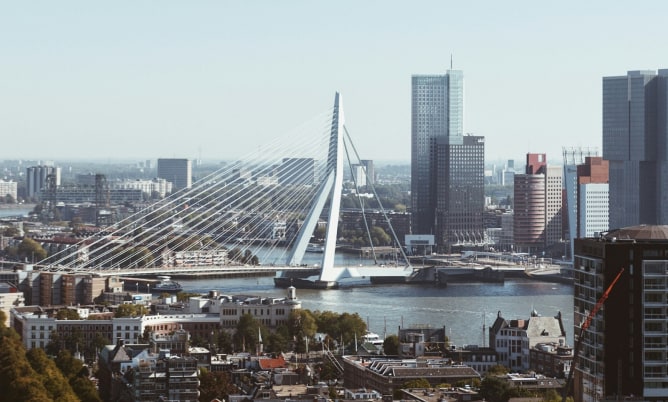 Erasmusbrug en skyline van Rotterdam overdag.